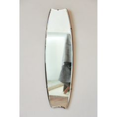 a mirror hanging on the wall in front of a person's head and coat