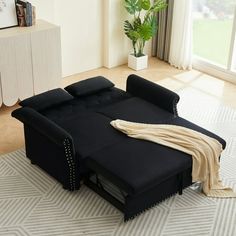 a black couch sitting on top of a white rug