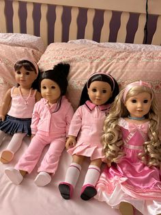 five dolls sitting on top of a bed next to each other in pink dresses and socks