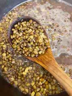 a wooden spoon stirring some food in a pot