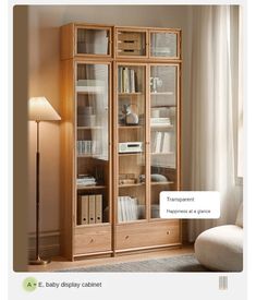 a wooden bookcase with glass doors and drawers in a living room next to a lamp