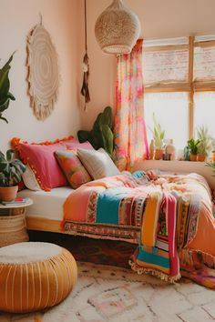 a bed with colorful blankets and pillows in a room next to a potted plant