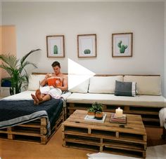 a man sitting on top of a bed in a living room