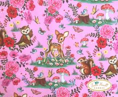 a pink fabric with deer and flowers on it's side, in front of a background