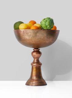 a large metal bowl filled with lots of fruit