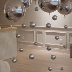 silver balloons are suspended from the ceiling in an empty room