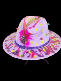 Description: Step into a world of color and light with this unique LED hat, designed for the ultimate festival experience. This one-of-a-kind piece is perfect for Burning Man, raves, neon-themed events, and any festival where you want to stand out and shine. Our Homoraver hats are the evolved version of Homo sapiens, created for those with higher perception levels--the awakened ones who see, understand, and need to unite. This hat isn't just an accessory; it's a statement. Each hat features: A vibrant, hand-painted design that glows under blacklight, making you the center of attention. LED lights that create a mesmerizing light show, perfect for night events. Unique symbols and patterns that reflect creativity and individuality. Feather and small figurine embellishments for an added touch Creative Hats, Unique Symbols, Burning Man Festival, Small Figurines, Themed Events, World Of Color