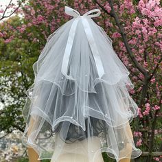 the back of a woman's dress with a veil on it