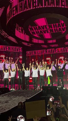 a group of people standing on top of a stage with their hands in the air