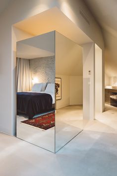 a mirrored room with a bed in the corner and an area rug on the floor