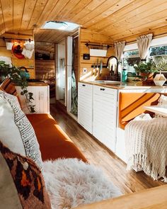 the interior of a tiny home with wood paneling and white furniture, including an orange couch