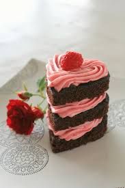 three brownies with pink frosting and a single red rose