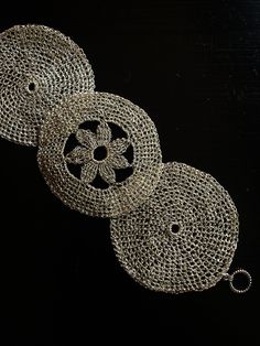 three silver doily on a black background