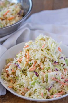 a white bowl filled with coleslaw next to another bowl full of coleslaw