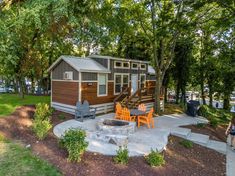 a small house with a fire pit in the front yard