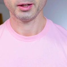 a close up of a person wearing a pink shirt