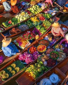 several boats filled with lots of different types of fruits and veggies for sale