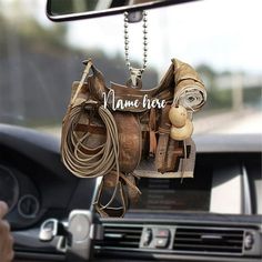 there is a horse saddle hanging from the car's rearview mirror, and it says name here