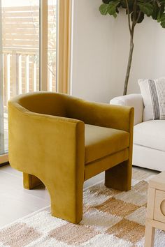 a yellow chair sitting on top of a rug in a living room