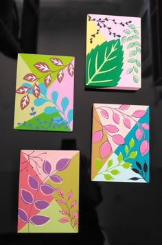 four square paintings with leaves and flowers painted on them