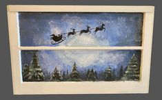 two paintings of santa's sleighs flying through the sky over trees