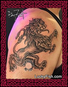 a lion tattoo on the back of a woman's shoulder and arm, with an ornate border around it