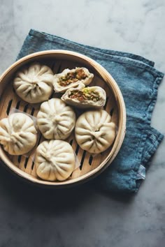 small dumplings in a wooden bowl on top of a blue cloth next to a pair of jeans