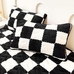 two black and white pillows sitting on top of a bed