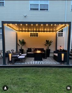 an outdoor living area is lit up with string lights and furniture under the pergolated roof