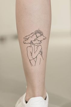 a woman's leg with a tattoo on it and the sun behind her head