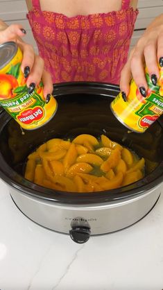 a woman is pouring orange juice into a crock pot