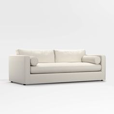 a white couch sitting on top of a white floor