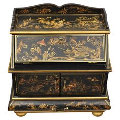 an ornate black and gold painted chest with figures on the front, two drawers at the bottom