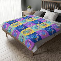 a bed with a colorful quilt on top of it