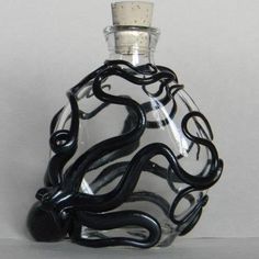 a black and white glass bottle with an octopus inside