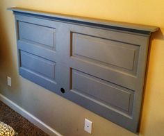 a gray headboard with two doors on it