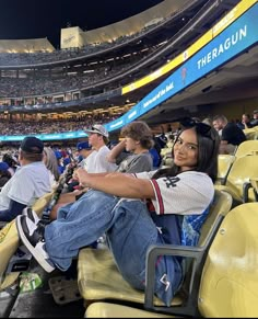 a woman sitting in the stands at a baseball game