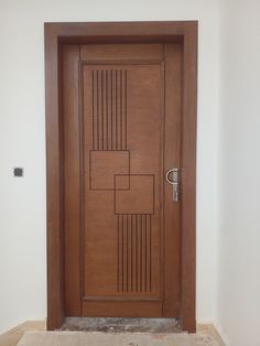 a wooden door in a room with tile flooring on the ground and white walls