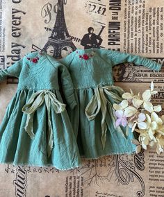 a green dress with flowers on the bottom and an eiffel tower in the background