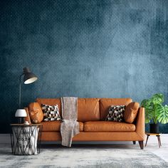 a living room with a couch, table and potted plant on the floor next to it