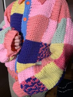 a woman wearing a multicolored crocheted sweater