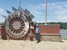 a woman standing in front of a large metal sign