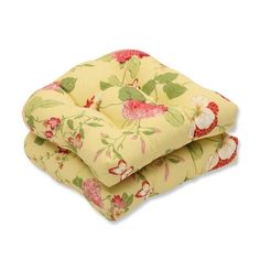 two yellow floral cushions stacked on top of each other, one with red and white flowers