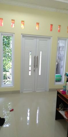 an empty room with two doors and several pieces of luggage sitting on the floor in front of them