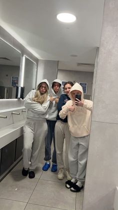 four people taking a selfie in the bathroom