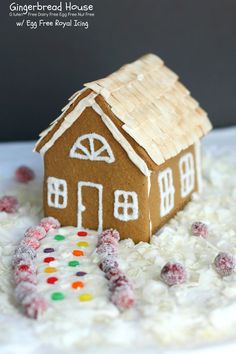 a gingerbread house is sitting in the middle of some white rice and sprinkles