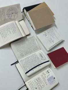 several open notebooks and papers spread out on top of each other, including one with writing