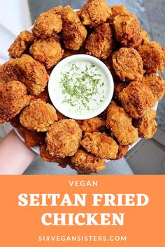 a person holding a plate with fried chicken on it and the words vegan written in white