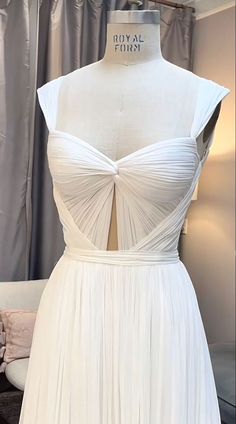 a white dress is displayed on a mannequin