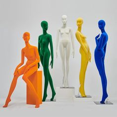 five different colored mannequins sitting on top of each other